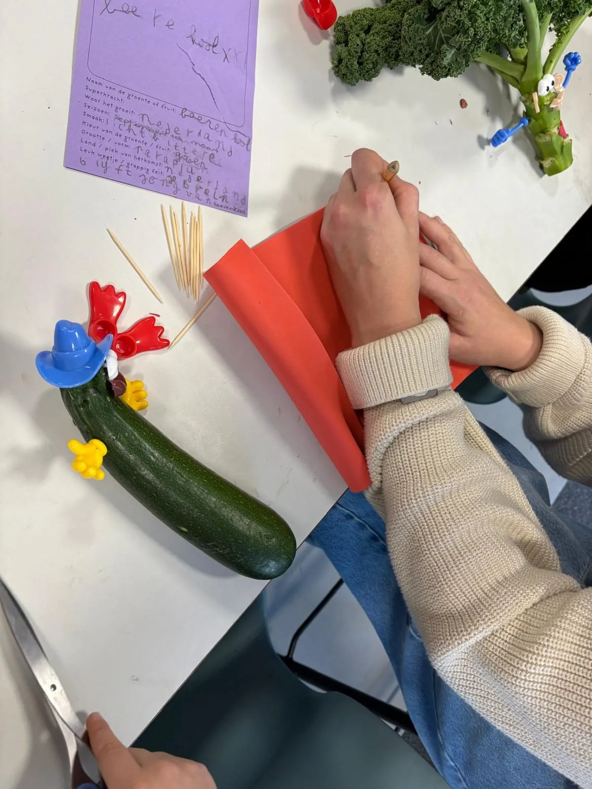 Handen die een courgette versieren, naast het ingevulde paspoort