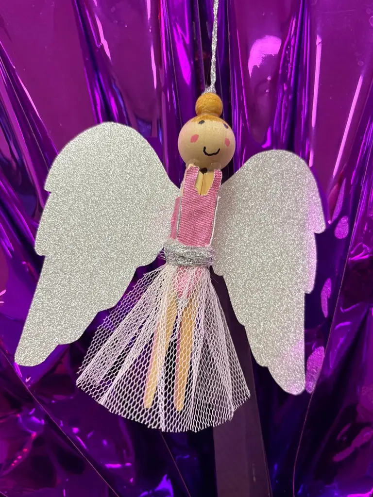 Een engeltje van glitterkarton en tule, tegen een paarse folie-achtergrond.
